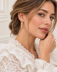 Boucles d’oreilles Courcelles 43 mm en plaqué or, créoles ciselées, portée vue de profil en gros plan.