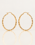 Boucles d’oreilles Courcelles 43 mm en plaqué or, créoles ciselées, paire vue de face sur fond clair avec reflet.