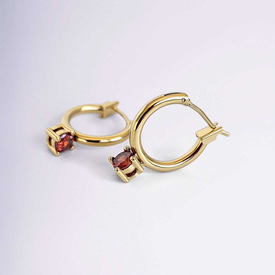 Boucles d’oreilles dorées avec zircon rouge