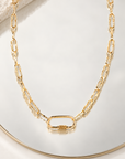 Collier George V de 39 cm en plaqué or, chaîne à maillons texturés et fermoir ovale présentés sur un miroir avec une pierre claire.
