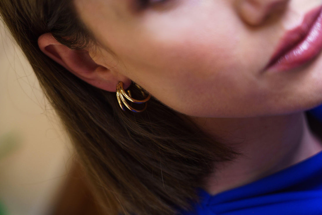 Femme portant les Boucles Teresa, créoles triples dorées
