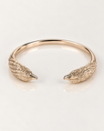 Jonc Aigle en plaqué or 18 carats, vue du dessus des deux têtes sculptées aux plumes en relief sur fond clair avec reflet miroir