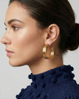 Boucles d’oreilles Lucca en plaqué-or portées, créoles texturées élégantes sur fond clair – Jossepo