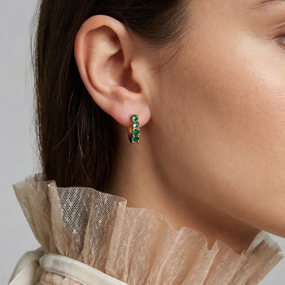 Détail des mini créoles Mathéo en plaqué or avec pierres vertes sur l’oreille – Jossepo