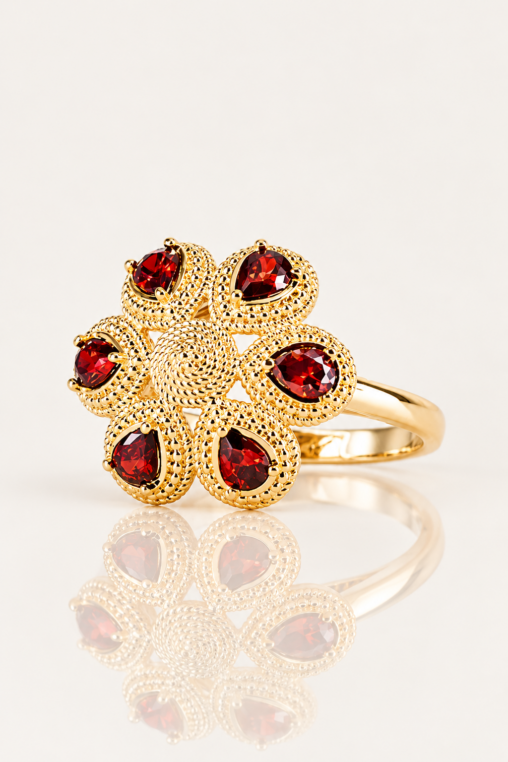 Bague Fergui en plaqué or 18 carats, fleur à six pierres rouges vue de face légèrement de côté, avec reflet miroir