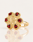 Bague Fergui en plaqué or 18 carats, fleur à six pierres rouges vue de face légèrement de côté, avec reflet miroir