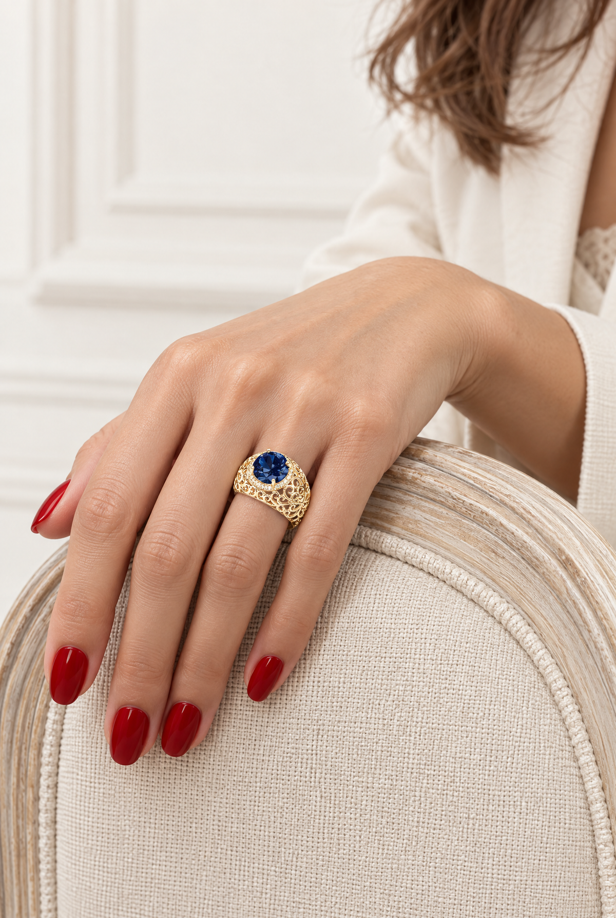 Bague Safiro à pierre bleue portée à la main sur un fauteuil clair