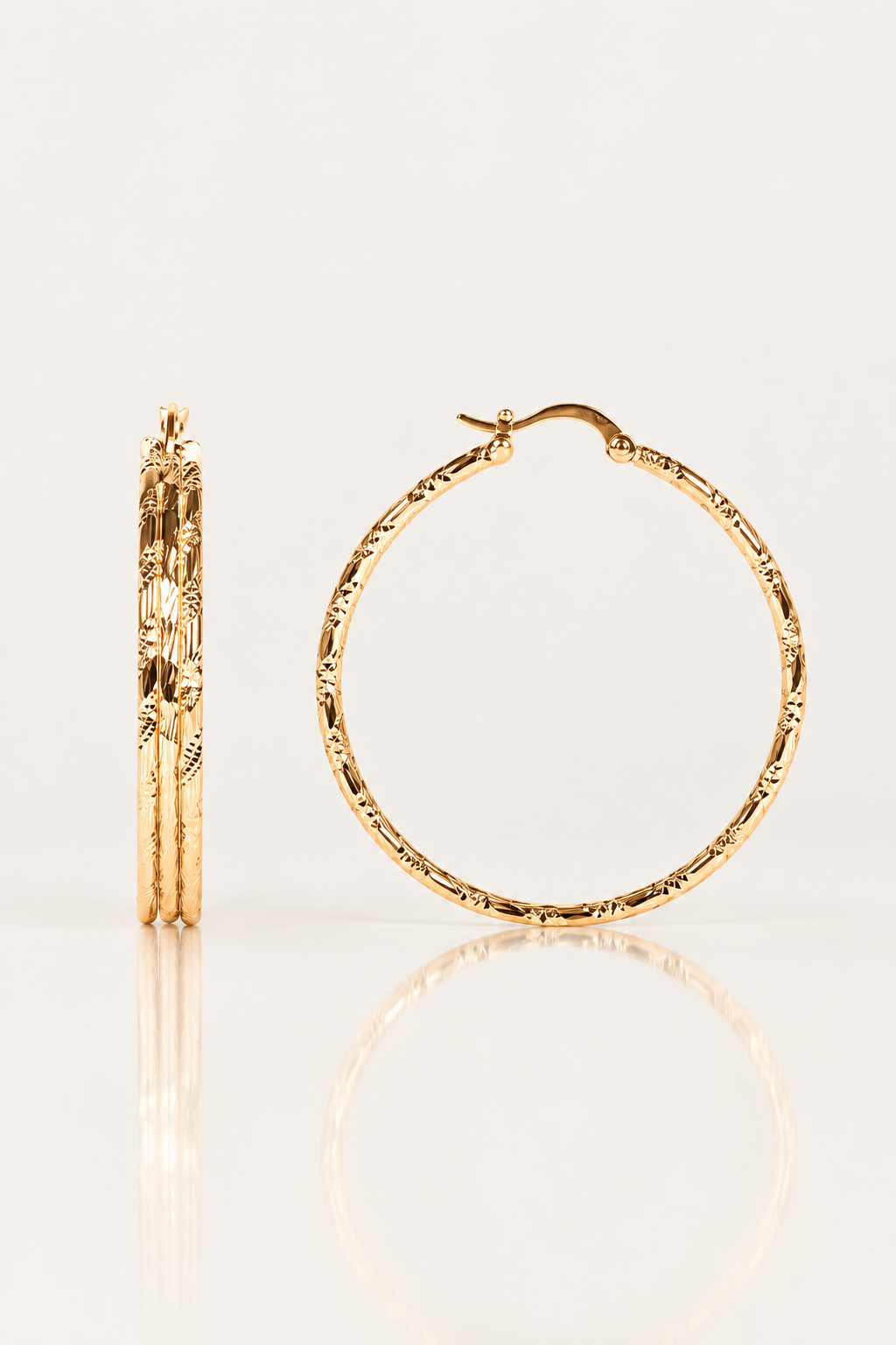 Boucles d’oreilles Courcelles 43 mm en plaqué or, créoles ciselées, vues de face et de profil sur fond clair avec reflet.