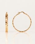 Boucles d’oreilles Courcelles 43 mm en plaqué or, créoles ciselées, vues de face et de profil sur fond clair avec reflet.