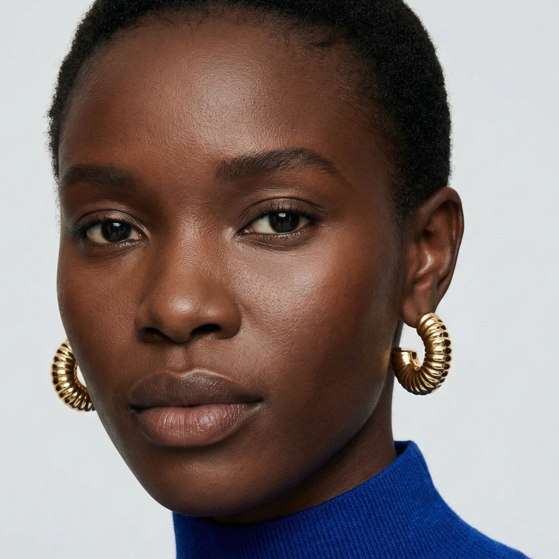 Boucles d’oreilles Léoni créoles texturées en plaqué or portées par un modèle – Jossepo