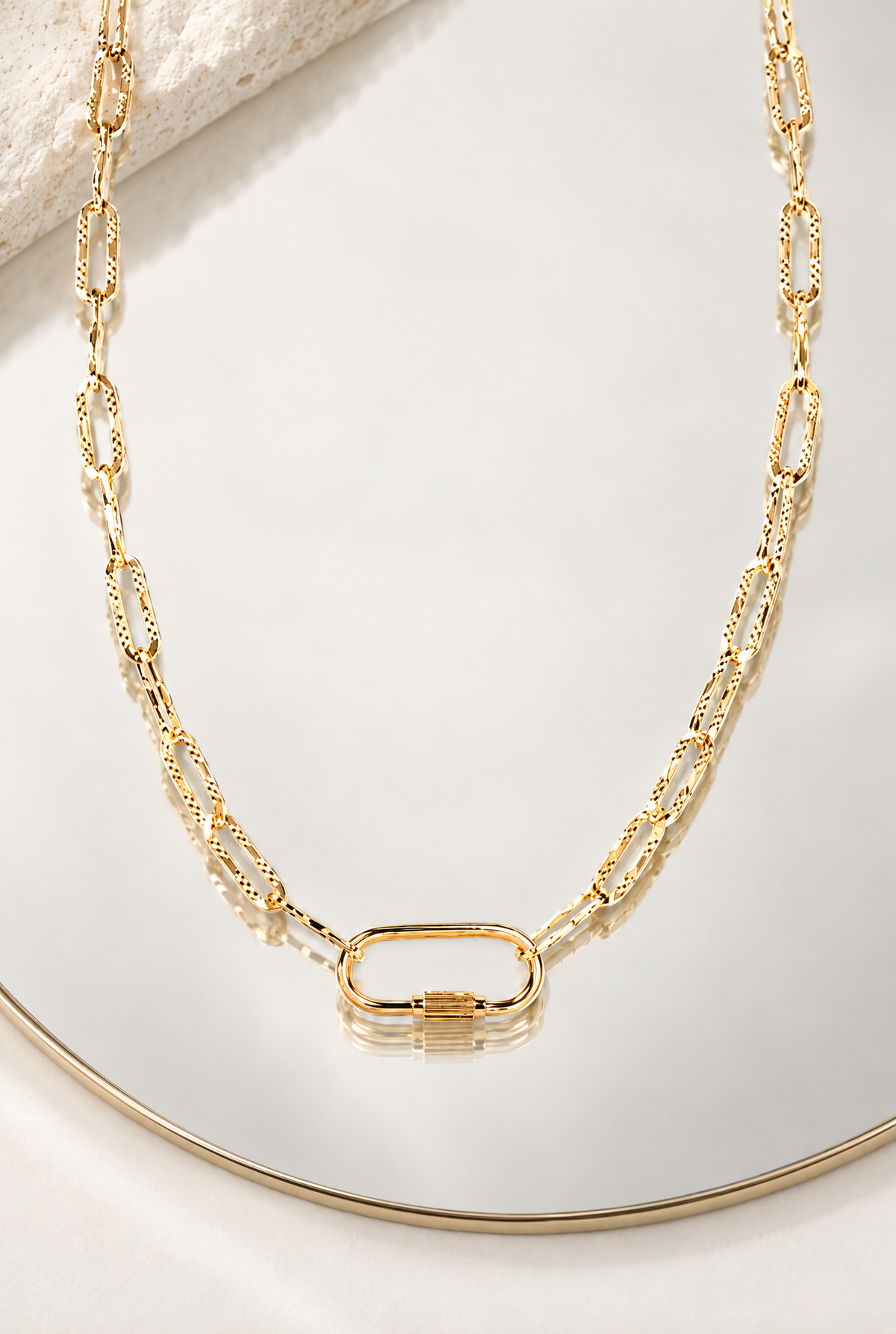 Collier George V de 39 cm en plaqué or, chaîne à maillons texturés et fermoir ovale présentés sur un miroir avec une pierre claire.