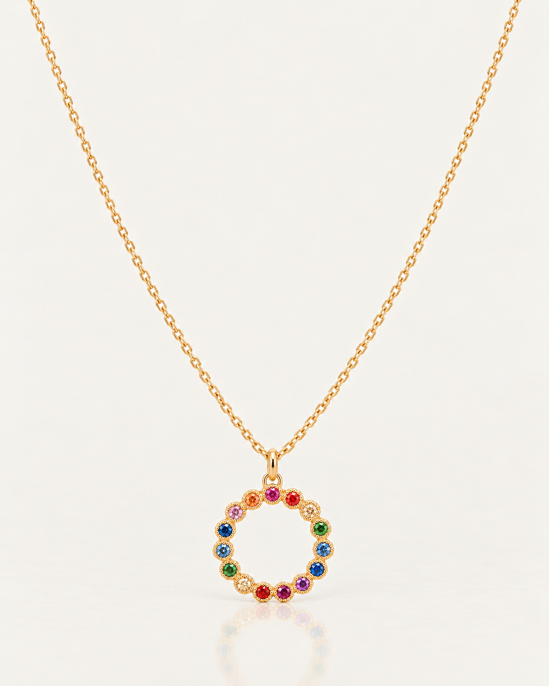 Collier Jasmin de 42 cm en plaqué or 18 carats, chaîne fine et pendentif cercle à pierres multicolores sur fond clair avec reflet miroir.