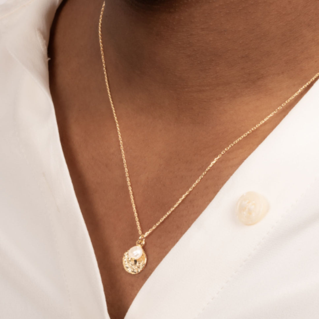 Collier médaille dorée avec perle en plaqué or 18 carats porté sur une chemise blanche – Jossepo
