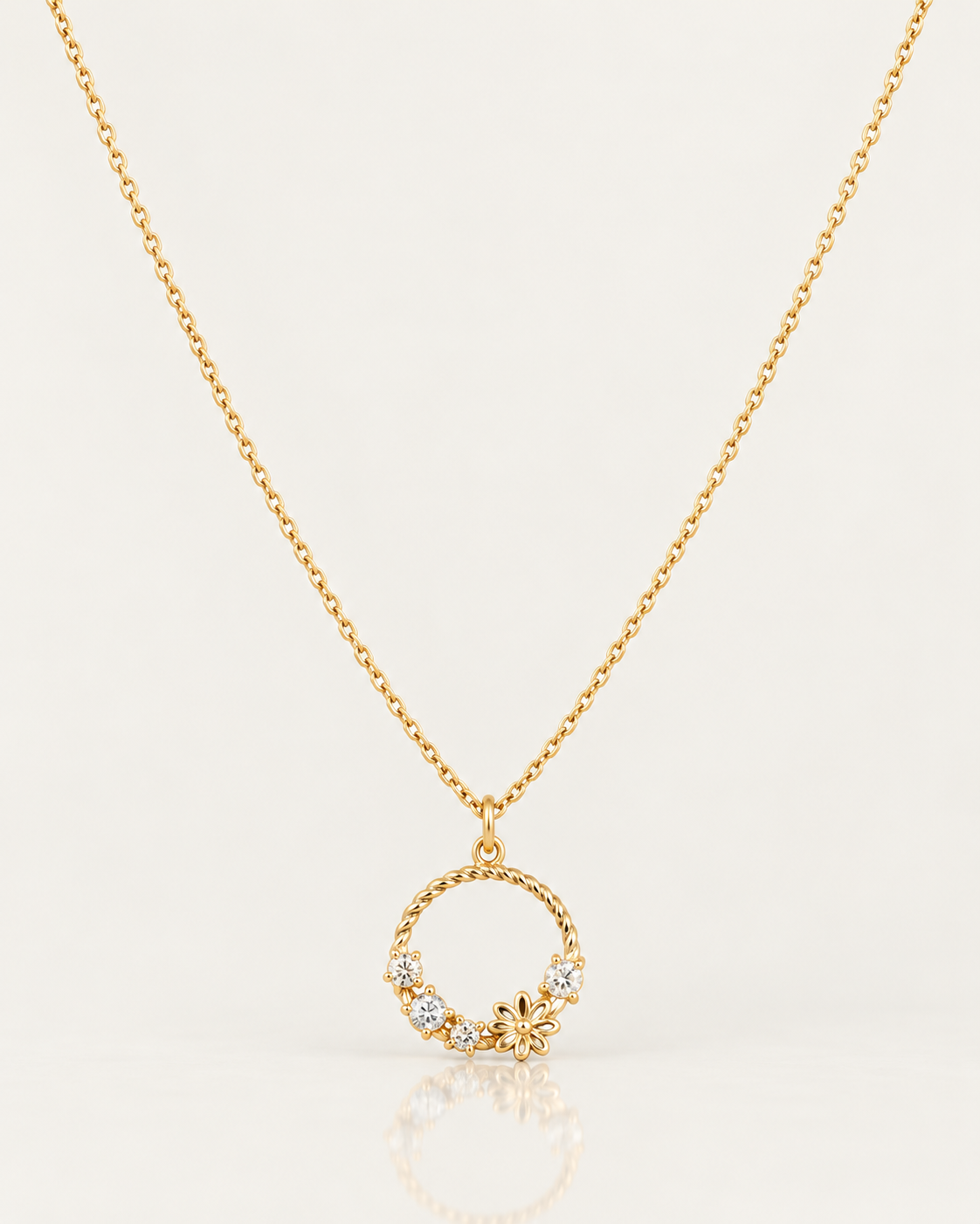 Collier Solférino de 45 cm en plaqué or 18 carats, chaîne fine et pendentif cercle floral de 16 mm sur fond clair avec reflet miroir.