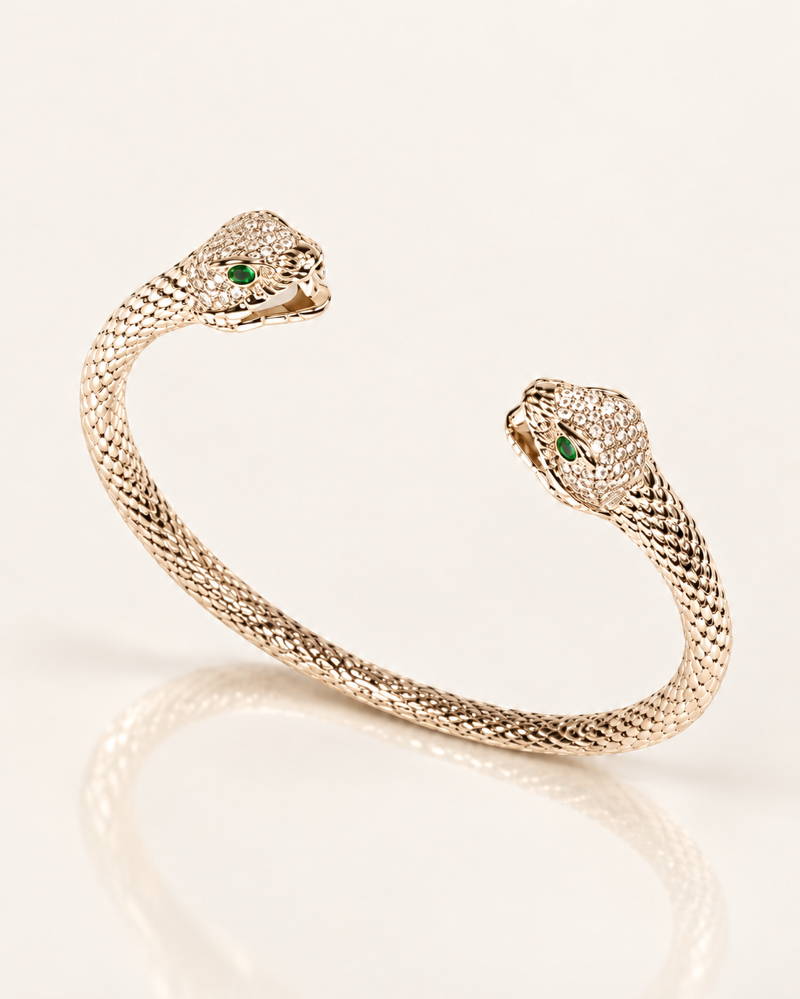 Jonc Serpent Zirconiums en plaqué or 18 carats, deux têtes de serpent ornées de zirconiums et yeux verts, vue de trois quarts avec reflet miroir