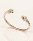 Jonc Serpent Zirconiums en plaqué or 18 carats, deux têtes de serpent ornées de zirconiums et yeux verts, vue de trois quarts avec reflet miroir