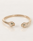 Bracelet jonc Serpent Zirconiums en plaqué or, corps texturé et têtes pavées de zirconiums, vue du dessus sur fond clair avec reflet