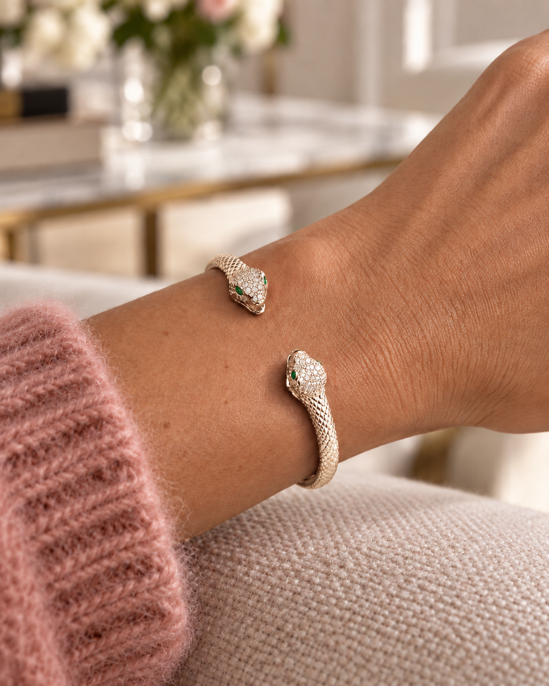 Jonc Serpent Zirconiums doré porté avec une maille rose poudré.